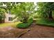 Landscaped backyard with lush greenery, a brick path, and stairs at 1976 Hedge Brooke Nw Trl, Acworth, GA 30101