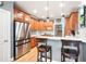 Modern kitchen with stainless steel appliances, wood cabinets, and stylish breakfast bar with seating at 1976 Hedge Brooke Nw Trl, Acworth, GA 30101