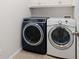 Well-equipped laundry room with front loading washer and dryer and overhead cabinets at 1976 Hedge Brooke Nw Trl, Acworth, GA 30101