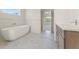 Modern bathroom with freestanding tub, marble floors, and wooden vanity with white countertop at 162 Spaulding Ln, Woodstock, GA 30188