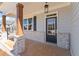 Front entryway featuring a covered porch with brick columns and a glass paneled door at 162 Spaulding Ln, Woodstock, GA 30188