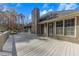 Wide angle view of a backyard with a wooden deck and trees surrounding the area at 3031 Clove Tree Ln, Woodstock, GA 30189