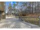 Backyard with a painted wooden deck and forest surrounding the yard at 3031 Clove Tree Ln, Woodstock, GA 30189