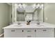 A bathroom features a double sink vanity, white cabinetry, and a large mirror, creating a functional design at 3031 Clove Tree Ln, Woodstock, GA 30189