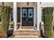 Elegant front entrance with double doors, decorative plants, and brick steps at 3845 Williams Point Dr, Cumming, GA 30028