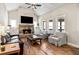 Vaulted living room with stone fireplace, built-in cabinets, hardwood floors, and large windows at 3845 Williams Point Dr, Cumming, GA 30028