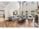 Inviting living room with vaulted ceiling, hardwood floors, fireplace, and large windows overlooking the yard at 3845 Williams Point Dr, Cumming, GA 30028