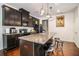 Modern kitchen featuring dark wood cabinets, granite countertops, and a kitchen island with seating at 7808 Rutgers Cir, Fairburn, GA 30213