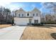 Charming two-story home featuring board and batten siding, a two-car garage, and manicured landscaping at 4825 Marco Ln, Cumming, GA 30028