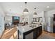 Open-concept kitchen with stainless steel appliances, granite countertops, and a view into the living area at 4825 Marco Ln, Cumming, GA 30028