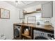 Organized laundry room with modern washer, dryer, wooden countertop and shelves at 4825 Marco Ln, Cumming, GA 30028