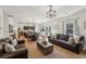 Open concept living room with hardwood floors, leather sofas, and a view into the dining area and kitchen at 4825 Marco Ln, Cumming, GA 30028