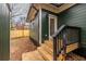 Backyard view of the green siding, wooden steps, black railing and a wooden fence at 973 Parsons Sw St, Atlanta, GA 30314