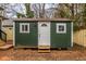 Backyard shed with green siding, white trim and a white door at 973 Parsons Sw St, Atlanta, GA 30314