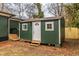 Backyard shed with green siding, white trim and a white door at 973 Parsons Sw St, Atlanta, GA 30314