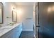 Well-lit bathroom featuring double vanity, marble countertop, updated fixtures, and stylish hexagon tile floors at 973 Parsons Sw St, Atlanta, GA 30314