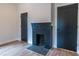 Bedroom featuring hardwood floors, neutral walls, a brick fireplace, and two dark-colored doors at 973 Parsons Sw St, Atlanta, GA 30314