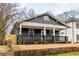 Beautiful home featuring a cozy front porch, with a stone retaining wall and freshly installed fencing at 973 Parsons Sw St, Atlanta, GA 30314