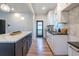 Well-lit kitchen featuring white cabinets, stainless sink, granite counters, backsplash and a breakfast bar island at 973 Parsons Sw St, Atlanta, GA 30314