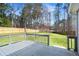Deck view of the fenced backyard with green grass, landscaping, and tall trees at 1833 Lost Mountain Rd, Powder Springs, GA 30127