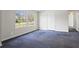 This bedroom offers natural light from two windows and ample space, complete with neutral walls and carpet flooring at 1833 Lost Mountain Rd, Powder Springs, GA 30127
