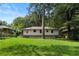 View of backyard from grassy lawn, shows the back of the brick and siding house at 2462 Macon Sw Dr, Atlanta, GA 30315