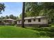 View of backyard from grassy lawn, shows the back of the brick and siding house at 2462 Macon Sw Dr, Atlanta, GA 30315