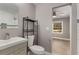 Bathroom with black shelving next to toilet, modern sink, and view to bedroom at 2462 Macon Sw Dr, Atlanta, GA 30315