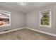 Bright bedroom featuring hardwood floors, neutral paint, and natural light from two windows at 2462 Macon Sw Dr, Atlanta, GA 30315