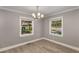 Inviting dining room featuring wood floors, neutral walls, modern lighting, and natural light from large windows at 2462 Macon Sw Dr, Atlanta, GA 30315