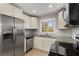 Bright kitchen featuring granite countertops, stainless steel appliances, subway tile backsplash, and white cabinetry at 2462 Macon Sw Dr, Atlanta, GA 30315