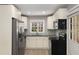 Well-equipped kitchen featuring stainless steel appliances, granite countertops, white cabinets, and hardwood floors at 2462 Macon Sw Dr, Atlanta, GA 30315