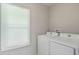 Bright laundry room features modern white washer and dryer next to a window at 2462 Macon Sw Dr, Atlanta, GA 30315
