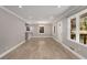 Open-concept living space featuring wood floors, neutral paint, large windows, and modern lighting fixtures at 2462 Macon Sw Dr, Atlanta, GA 30315