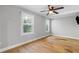 Bedroom with hardwood floors, neutral walls, modern ceiling fan, and two windows providing views of the exterior at 2672 Langland Ne Ct, Atlanta, GA 30345