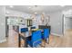 Dining area features a modern light fixture, gray walls, and a dark wood table with blue velvet chairs at 2672 Langland Ne Ct, Atlanta, GA 30345