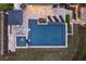Aerial view of a stunning backyard pool area with stone patio, lounge chairs, umbrella, and landscaped accents at 2672 Langland Ne Ct, Atlanta, GA 30345