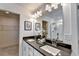 Well-lit bathroom with double sinks, modern vanity, large mirror, and a view of the walk-in closet at 2698 Ne Almand Ln, Conyers, GA 30013