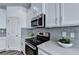 Modern kitchen featuring stainless steel appliances, gray subway tile backsplash and white cabinets at 2698 Ne Almand Ln, Conyers, GA 30013