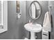 Charming powder room features a pedestal sink, decorative mirror, and fresh towel for guests' convenience at 3660 Lake Pass Ln, Suwanee, GA 30024