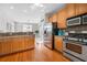 Well-equipped kitchen flows seamlessly to the dining area, featuring stainless steel appliances and wooden floors at 3660 Lake Pass Ln, Suwanee, GA 30024