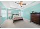 Bright primary bedroom showcasing a large bed, tray ceiling, and fresh blue paint at 3660 Lake Pass Ln, Suwanee, GA 30024