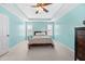 Bright primary bedroom showcasing a large bed, tray ceiling, and fresh blue paint at 3660 Lake Pass Ln, Suwanee, GA 30024