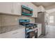 Close up of modern kitchen featuring stainless steel appliances, granite counters, white cabinets, and light tile backsplash at 186 Brandi Dr, Hiram, GA 30141