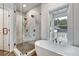 Bright bathroom featuring a glass-enclosed shower and a freestanding soaking tub by a window at 2171 James Aly, Atlanta, GA 30345