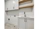 Functional laundry room with white cabinets, a utility sink, and practical countertops at 2171 James Aly, Atlanta, GA 30345