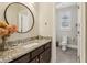 Elegant bathroom with granite countertop, dark wood vanity, and round mirror at 4224 Dogwood Bend Park, Duluth, GA 30096