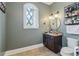 Stylish bathroom featuring a vanity with a granite countertop, wall lighting and an arched window at 4224 Dogwood Bend Park, Duluth, GA 30096
