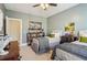 Charming bedroom featuring two beds, a ceiling fan, bookshelf, and shuttered windows, creating a relaxing atmosphere at 4224 Dogwood Bend Park, Duluth, GA 30096