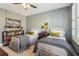 Bright bedroom with two beds, shuttered windows, a ceiling fan, and bookshelf for storage and display at 4224 Dogwood Bend Park, Duluth, GA 30096